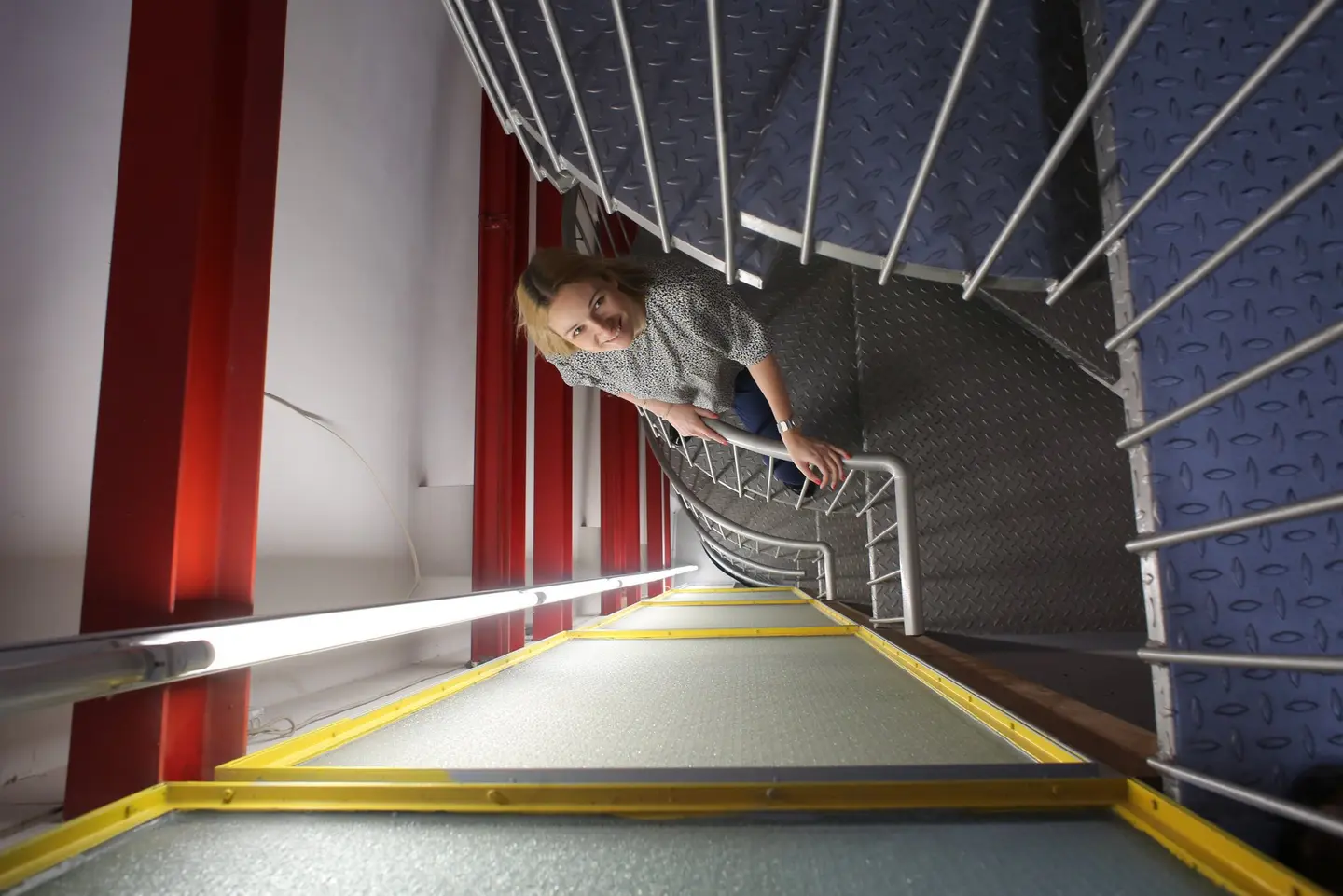 Eine Frau steht auf einer Wendeltreppe.