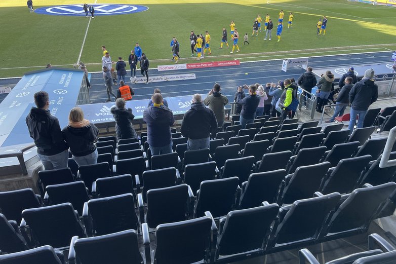 Eine Fußballmannschaft betritt das Spielfeld.