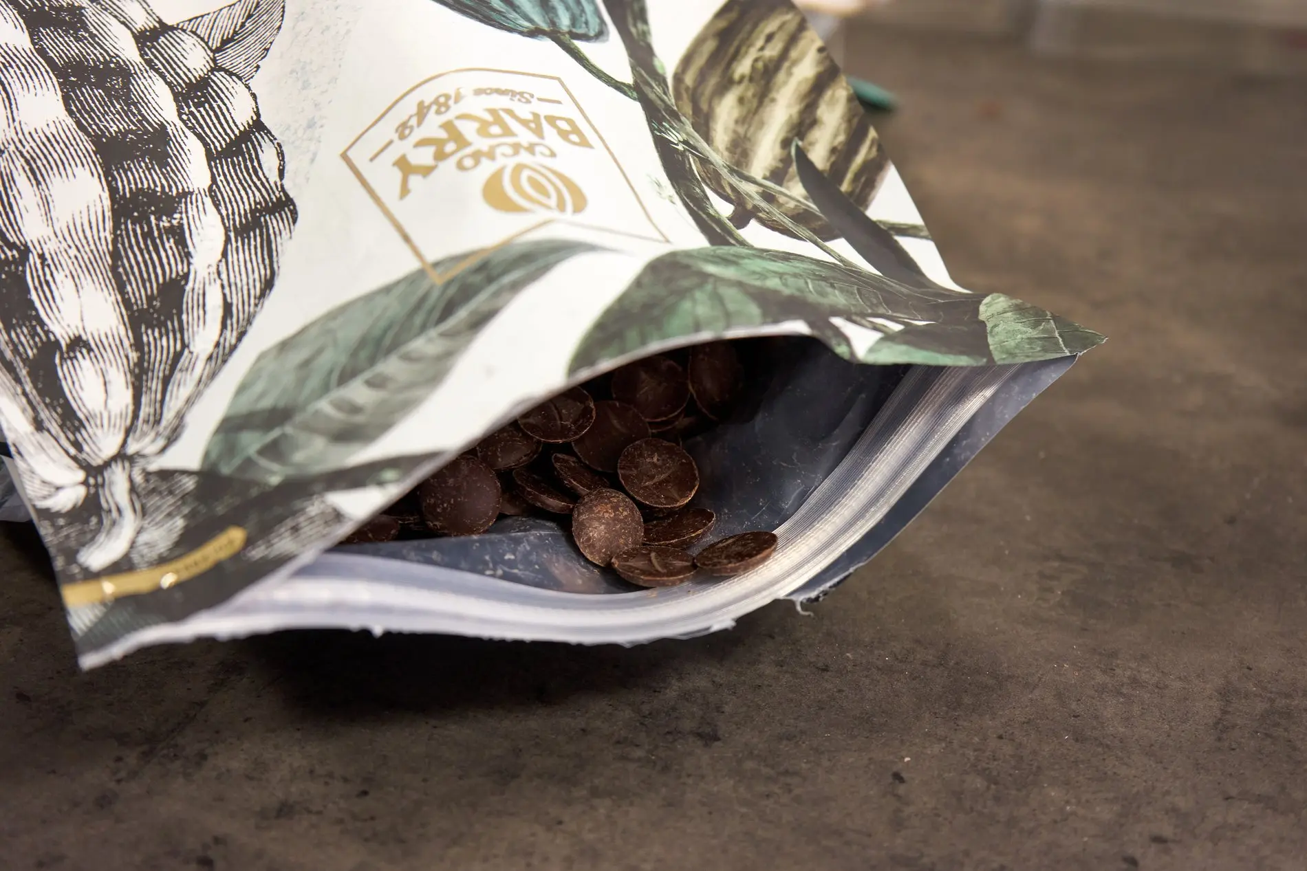 Eine offene Packung mit trockenen Kuvertürestücken. 