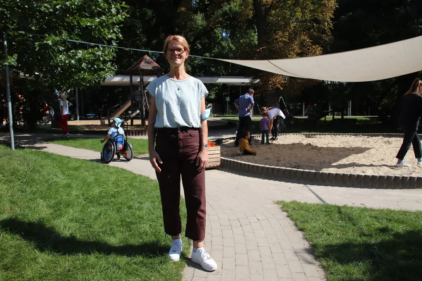 Eine Frau steht im Außengelände eines Kindergartens. 