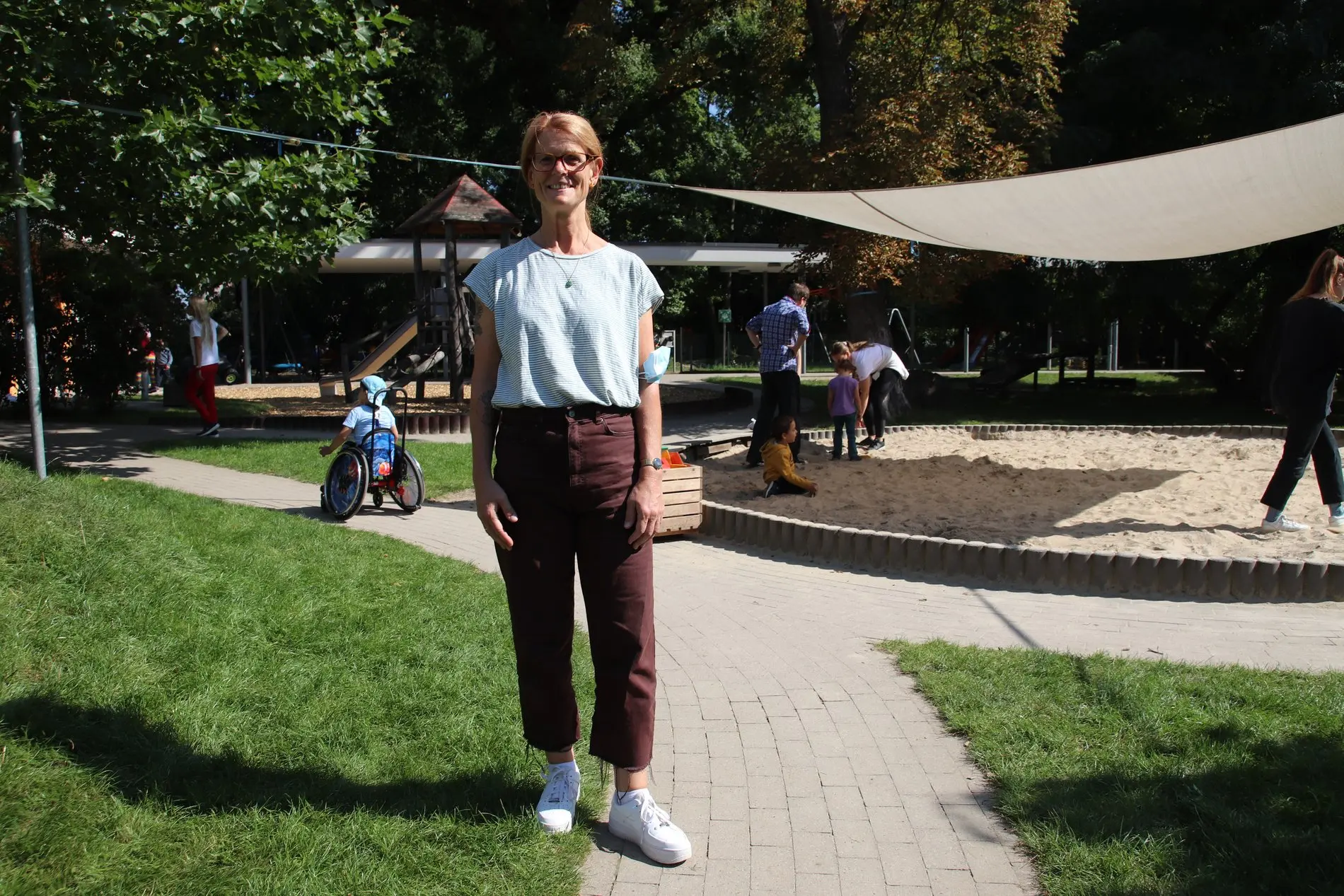 Eine Frau steht im Außengelände eines Kindergartens. 