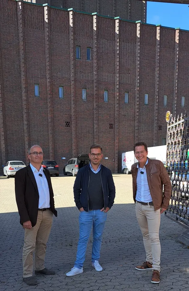 Drei Männer stehen vor der Härke Brauerei.