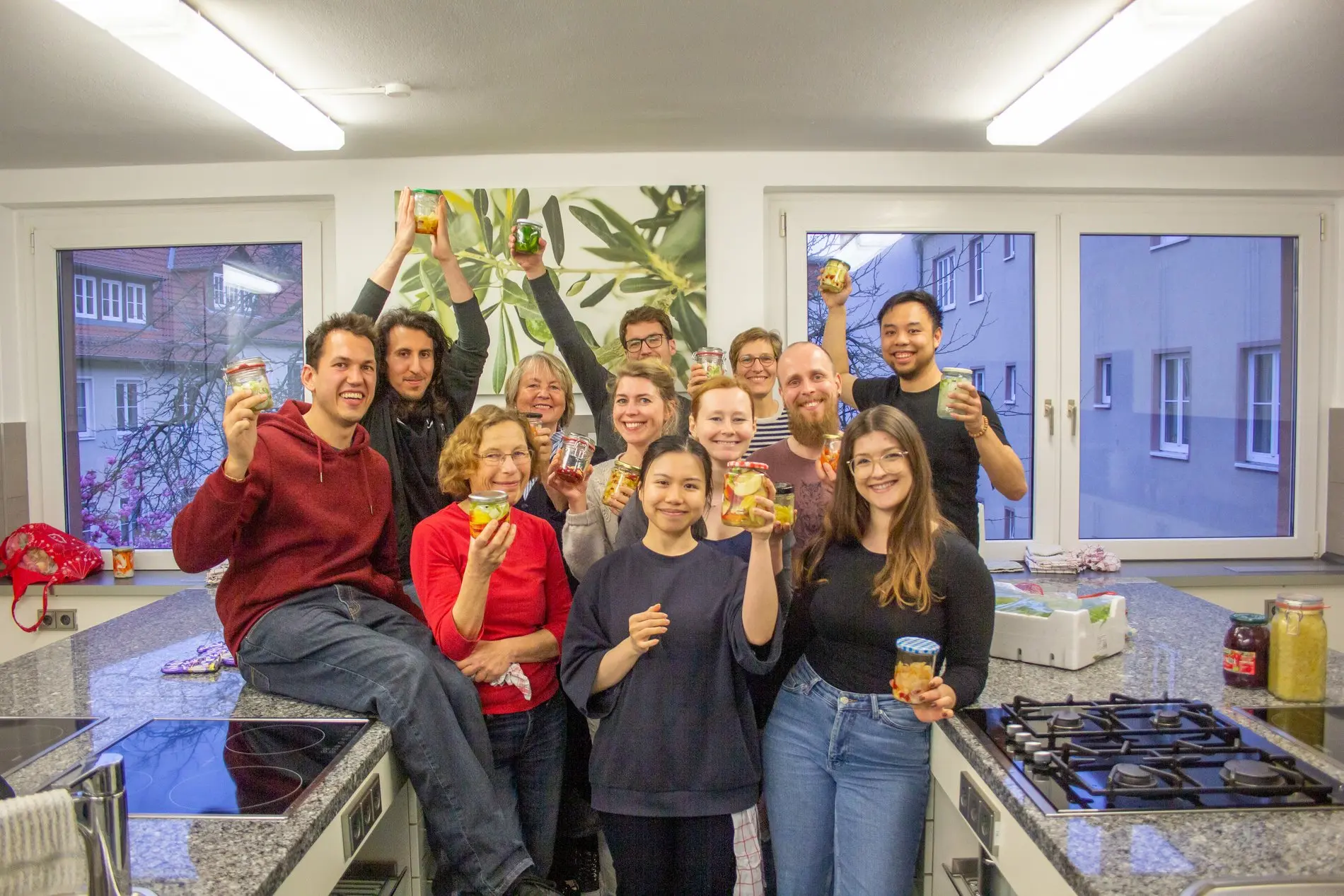 Ein Gruppenbild mit fröhlichen Menschen, die ihre selbst gemachten Konserven zeigen