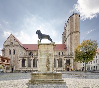 Man blickt auf den Braunschweiger Löwen auf dem Burgplatz, im Hintergrund der Dom St. Blasii