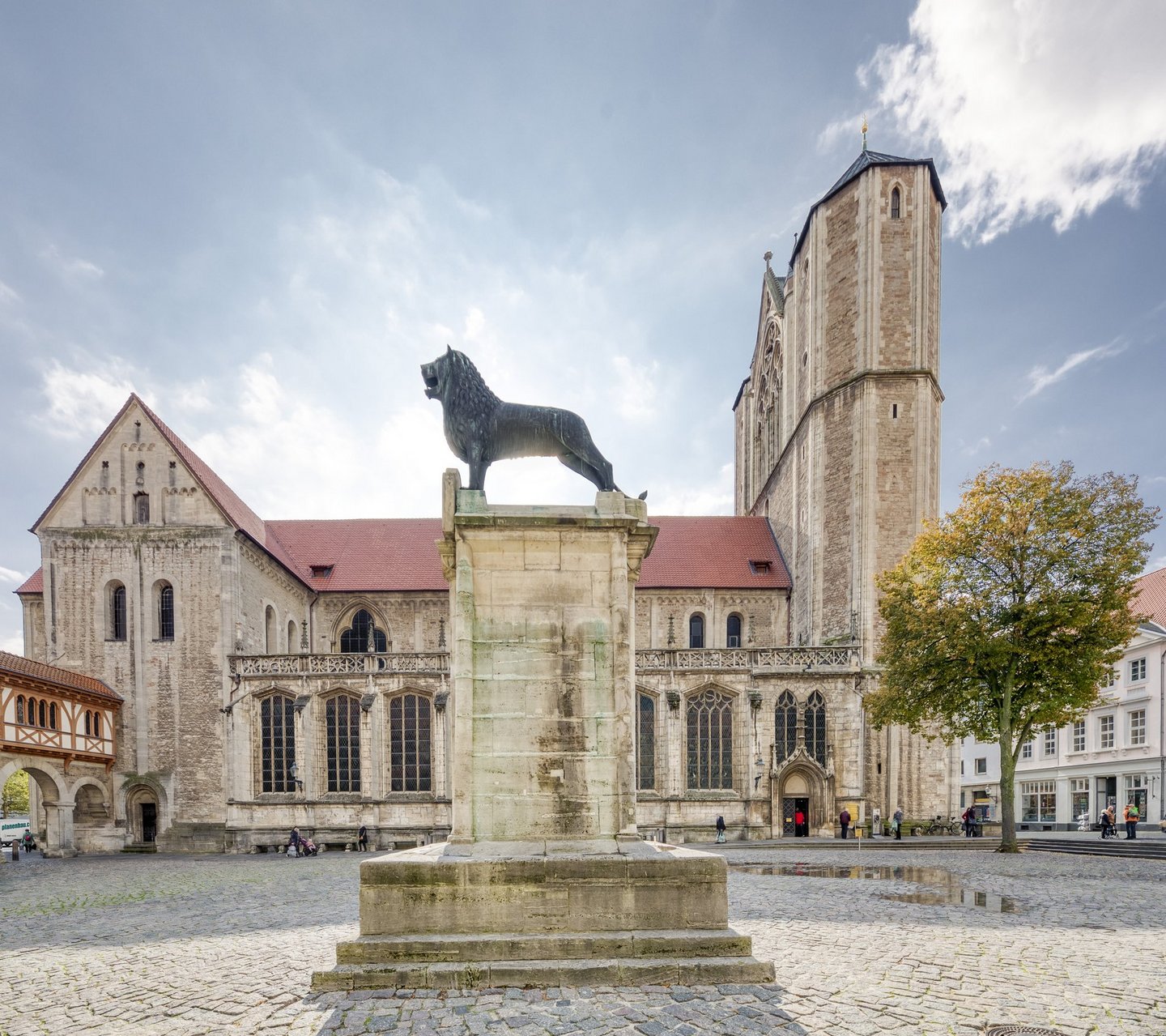 Man blickt auf den Braunschweiger Löwen auf dem Burgplatz, im Hintergrund der Dom St. Blasii