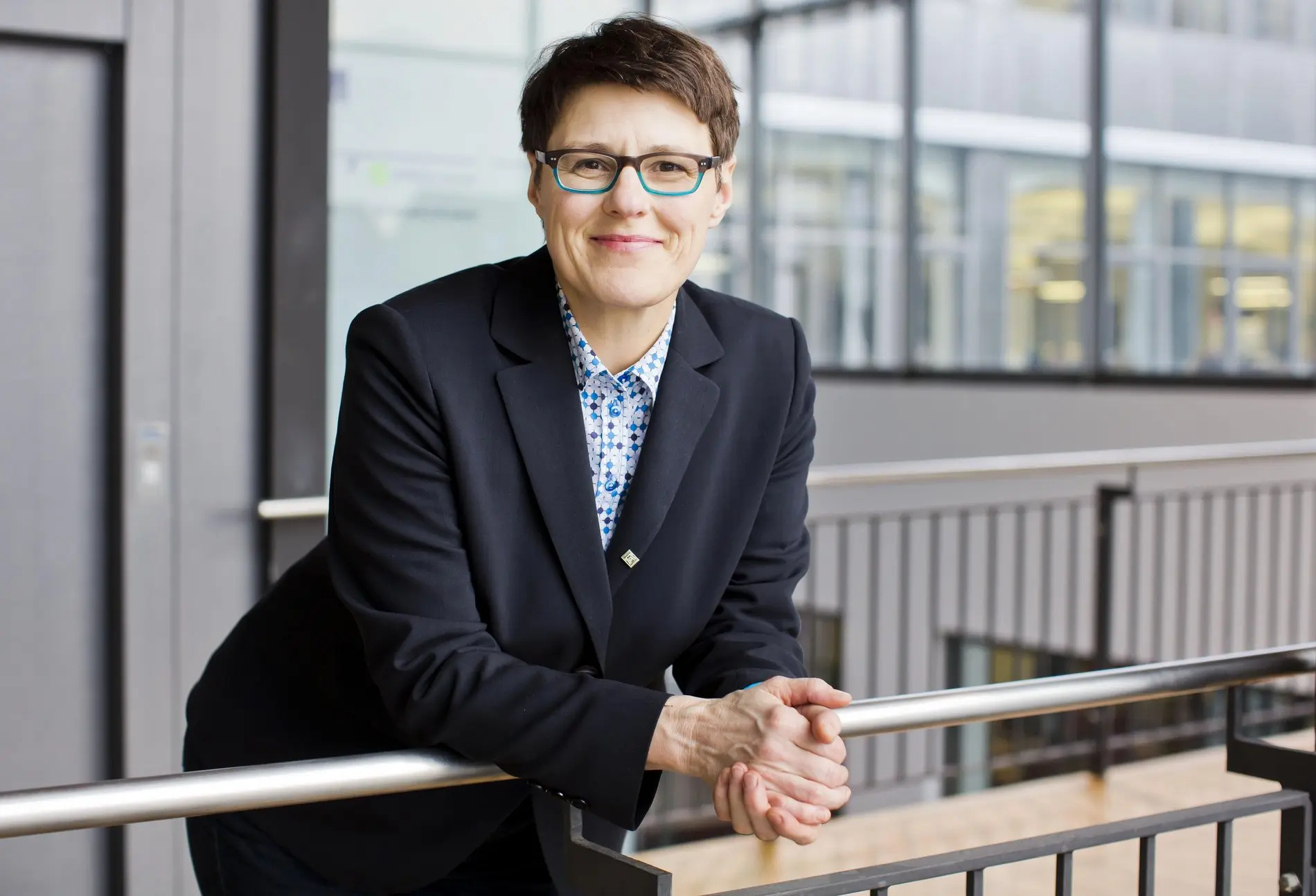 Eine Frau lehnt an einem Geländer.