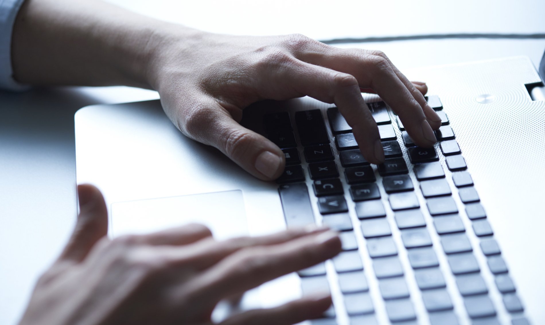 Hände auf einer Laptoptastatur