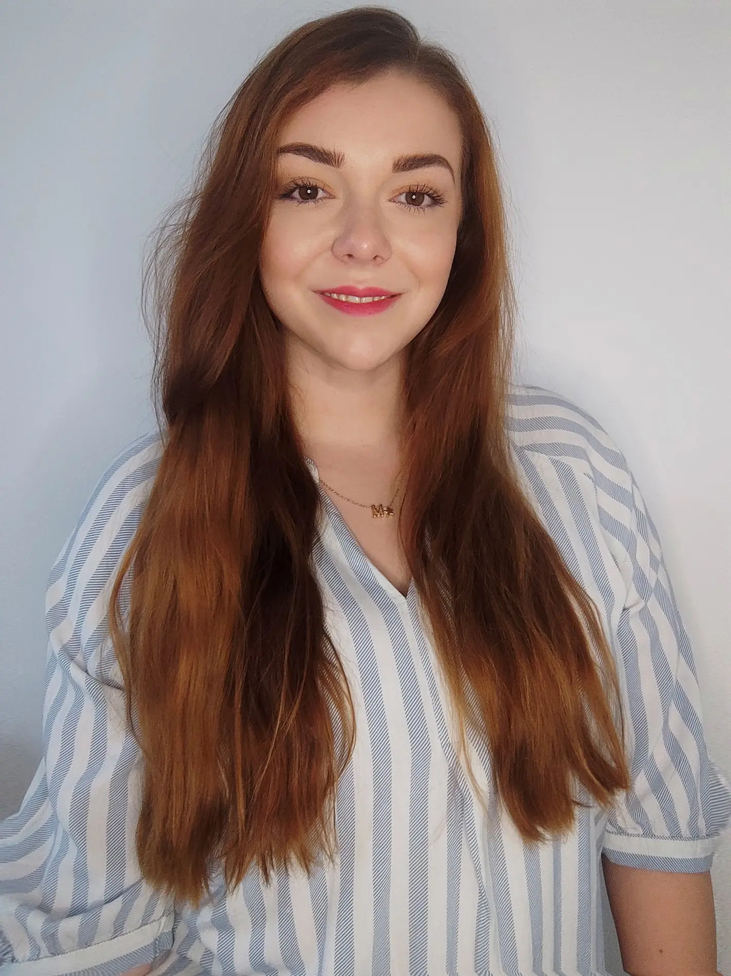 Portrait einer jungen Frau mit langen rotbraunen Haaren.