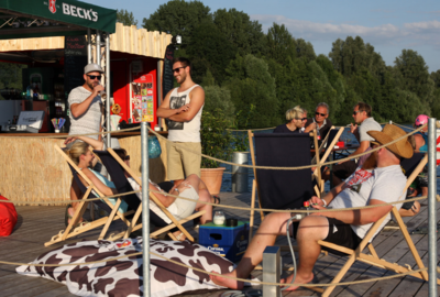 Menschen auf Liegestühlen auf einer künstlichen Insel auf dem Salzgittersee.