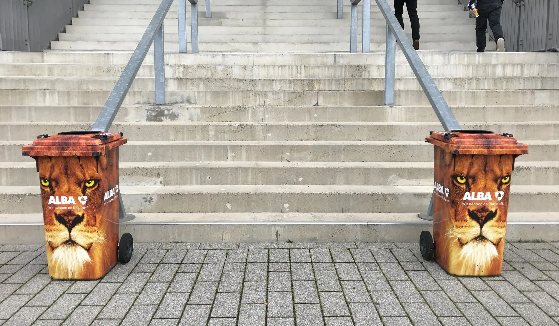 Zwei Mülltonnen mit Löwenkopf-Aufdruck.