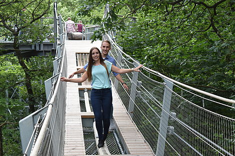 zwei junge Menschen gehen über eine Brücke