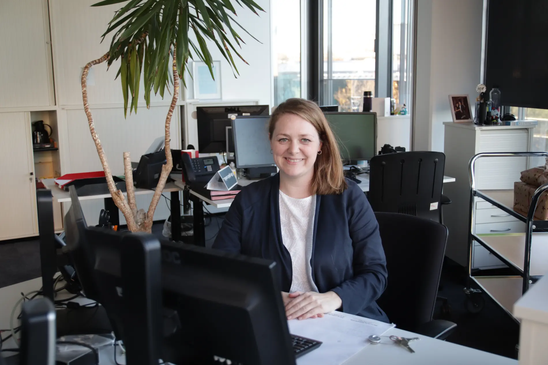 Eine Frau sitzt in einem Büro an einem Schreibtisch.
