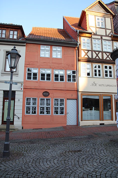 Ein oranges schmales Fachwerkhaus inmitten von Helmstedt.