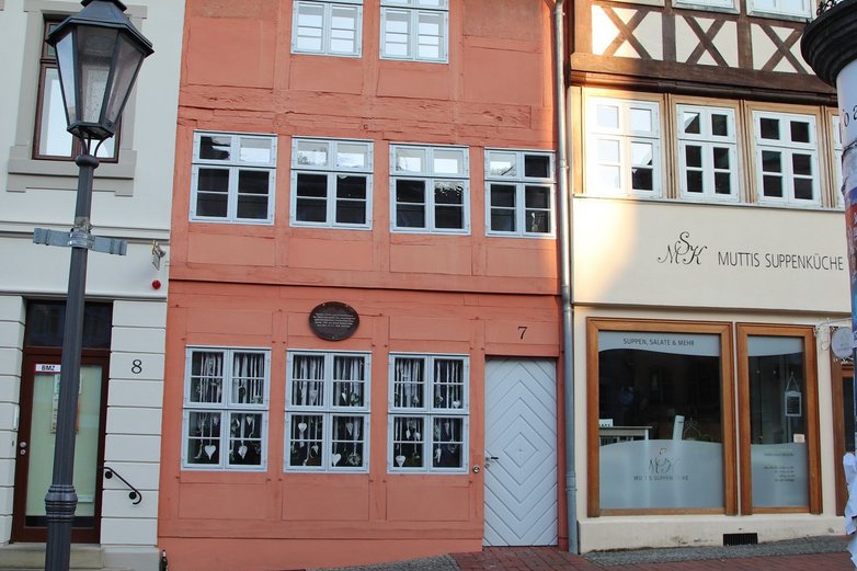 Ein oranges schmales Fachwerkhaus inmitten von Helmstedt.