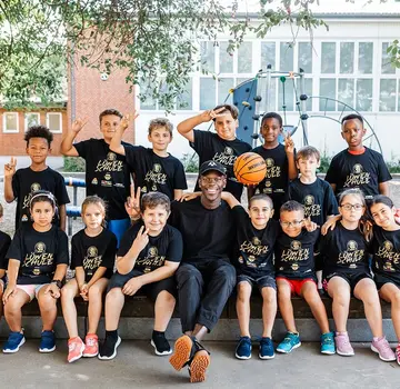 Die Teilnehmenden des Projektes Jump for Future rund um ihr Idol Dennis Schröder. (Bildrechte: Volksbank BRAWO/Nina Stiller)
