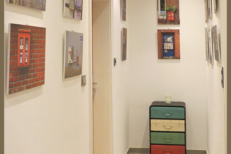 Ein Flur mit Kunstwerken an den Wänden.