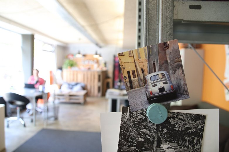 Ein Foto mit Kleinwagen hängt an einem Regal im Büro.