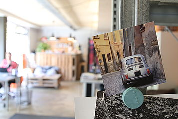 Ein Foto mit Kleinwagen hängt an einem Regal im Büro.