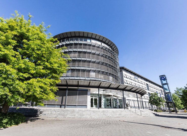 Ein moderner Bürokomplex in Braunschweig mit Baum bei Sonnenschein.