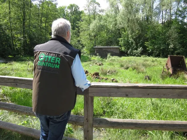 Dr. Oskar Kölsch am Zaun mit Blick auf Gehege