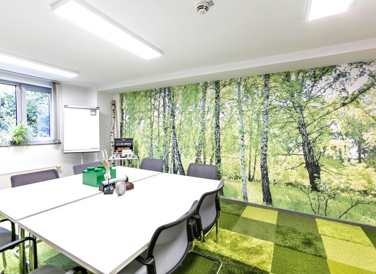 Ein Arbeitsraum mit Wandtapete mit Waldmotiv.