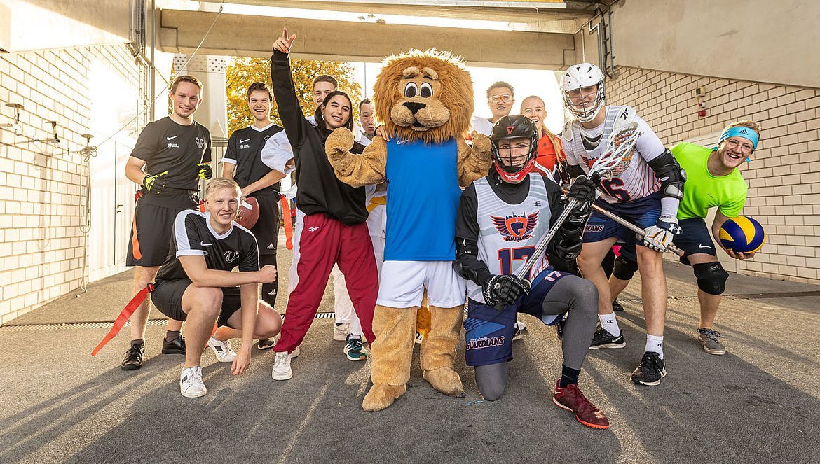 Sportler und Sportlerinnen verschiedener Sportarten posieren für ein Foto.