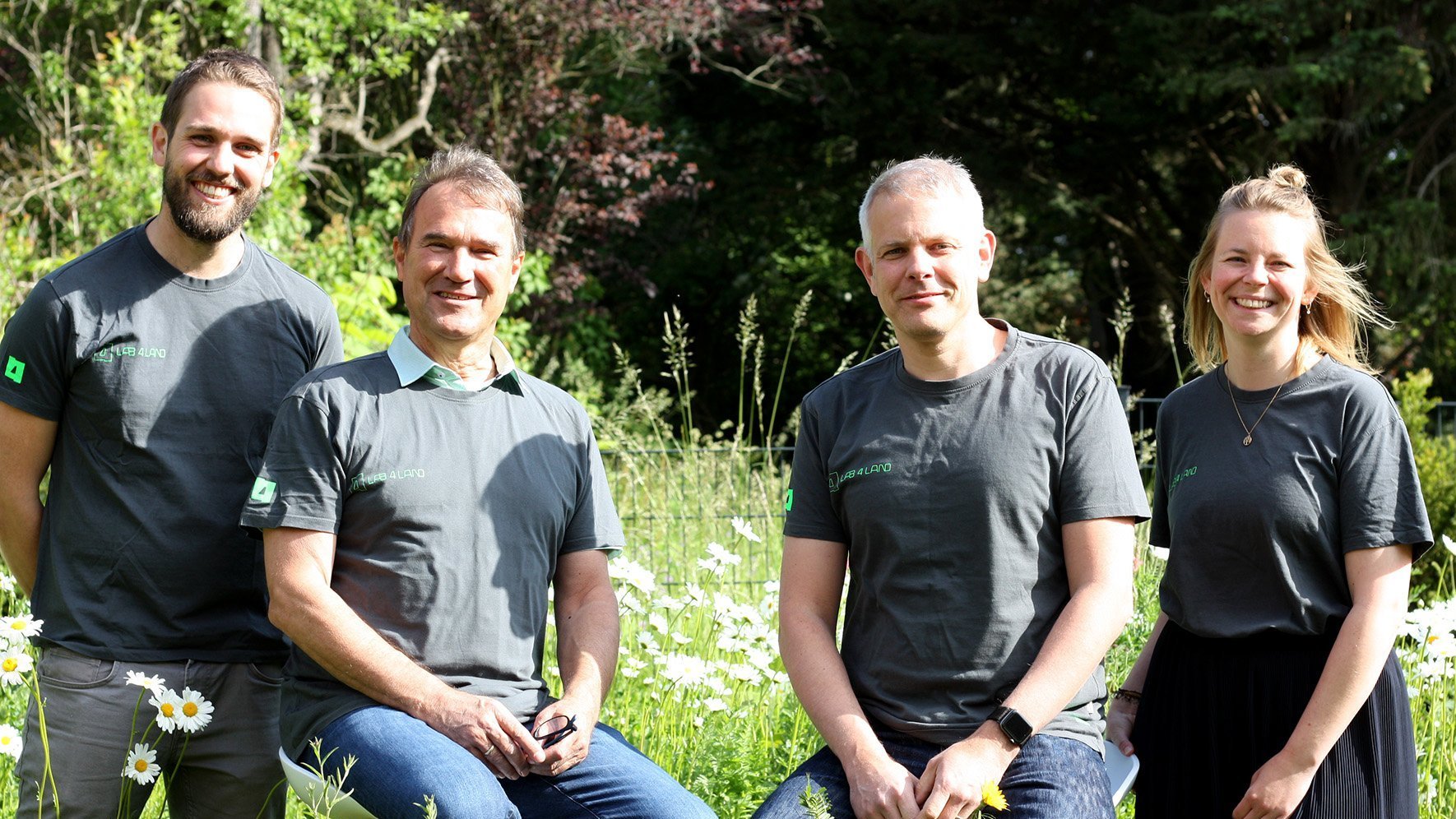 4 junge Leute in einheitlichen T-Shirts.