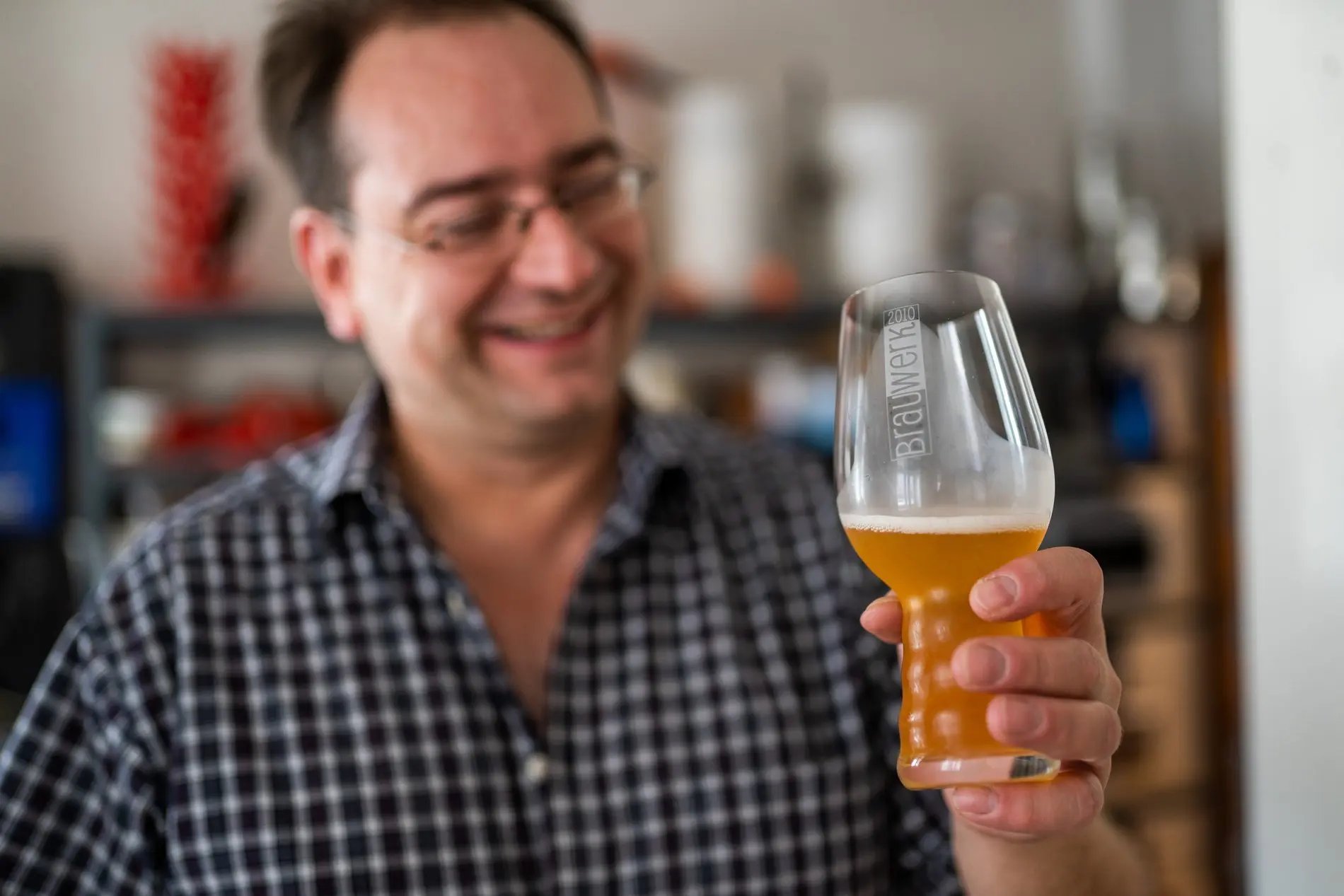 Ein Mann schwenkt ein Bierglas.