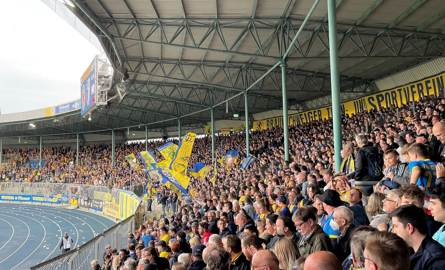 Eine vollbesetzte Fankurve in einem Fußballstadion.