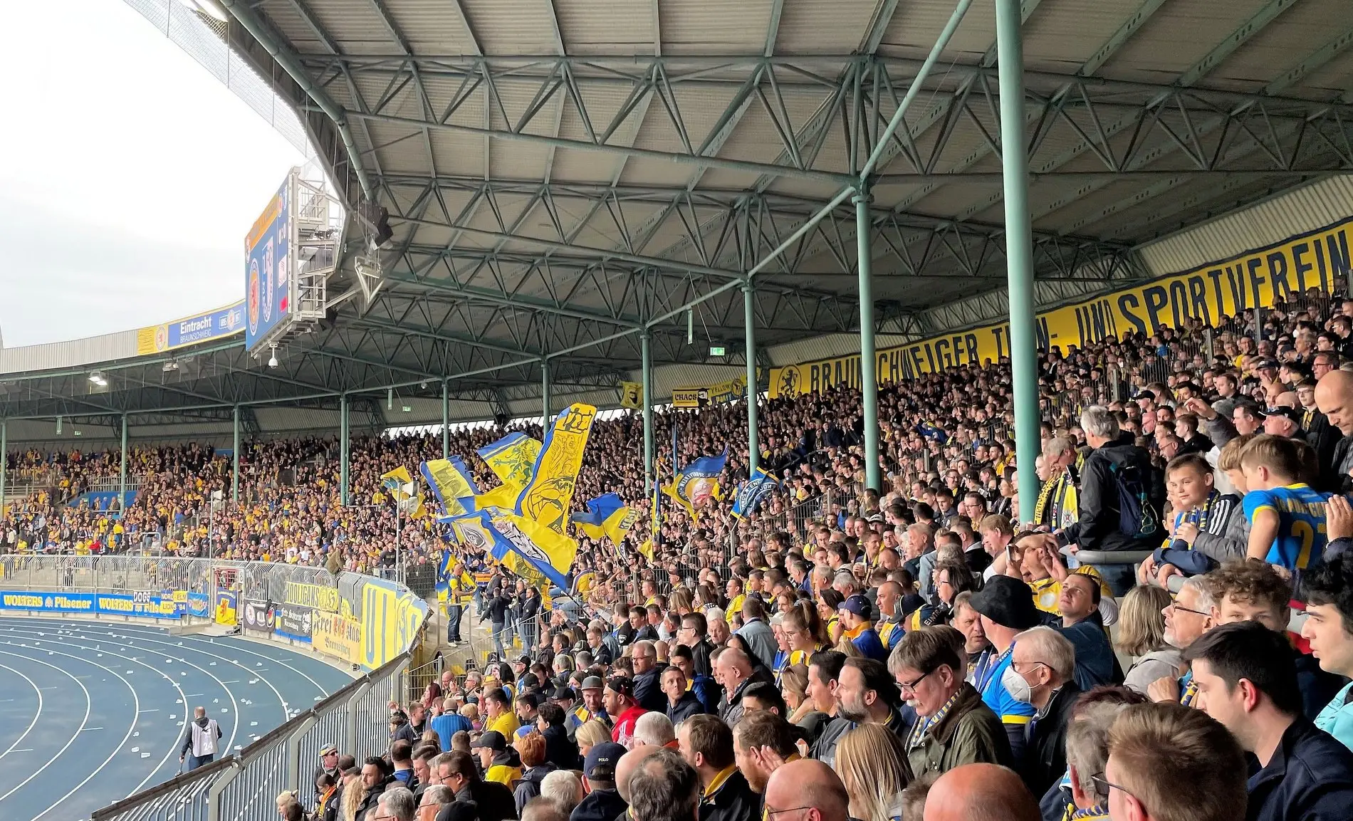 Eine vollbesetzte Fankurve in einem Fußballstadion.