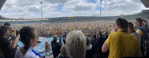 Eintrachtfans stehen auf dem Rasen des Stadions.