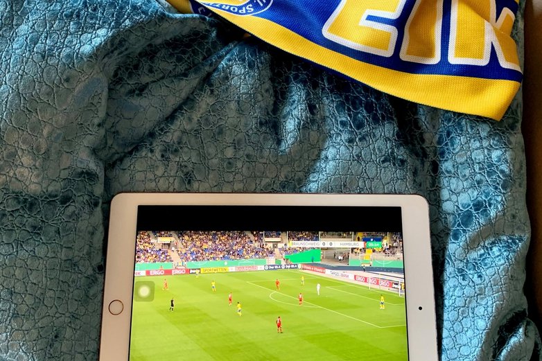 Ein IPad liegt auf einem Kissen, darauf ist das Eintracht-Spiel zu sehen.