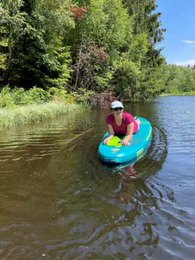 Eine Frau liegt auf einem SUP-Board.