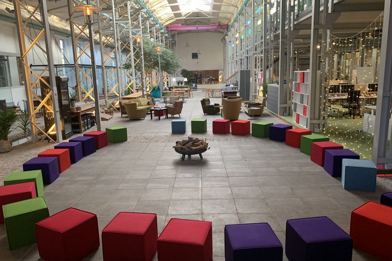 Ein Foyer mit bunten, zum Kreis gestellten Sitzgelegenheiten.