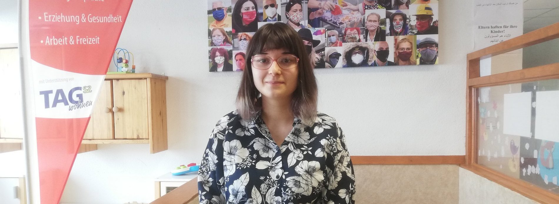 Eine dunkelhaarige Frau in einem Kinder-Spielbereich.