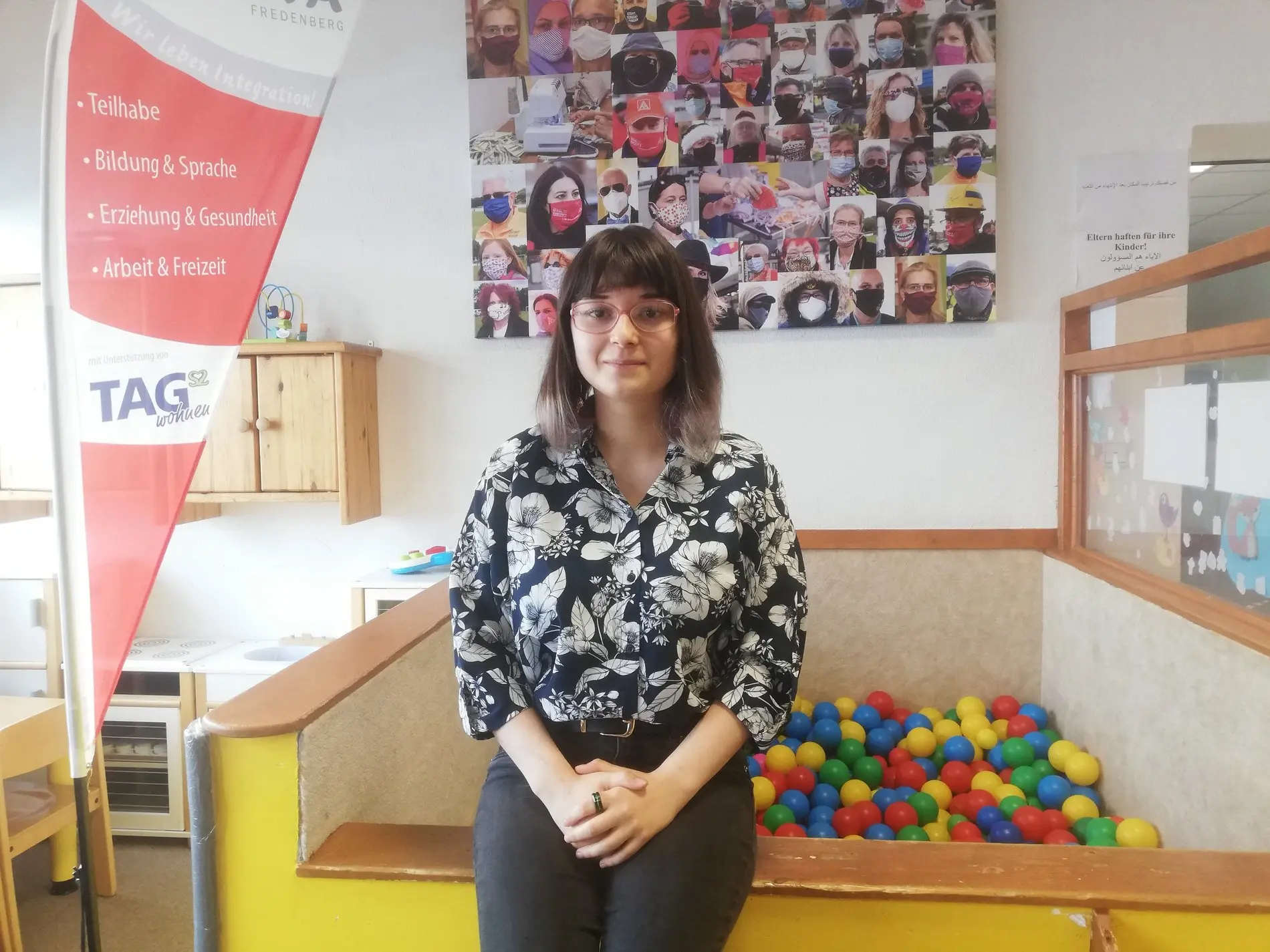 Eine dunkelhaarige Frau in einem Kinder-Spielbereich.