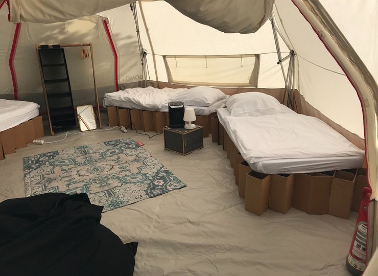 Mehrere Betten stehen in einem geräumigen Zelt.