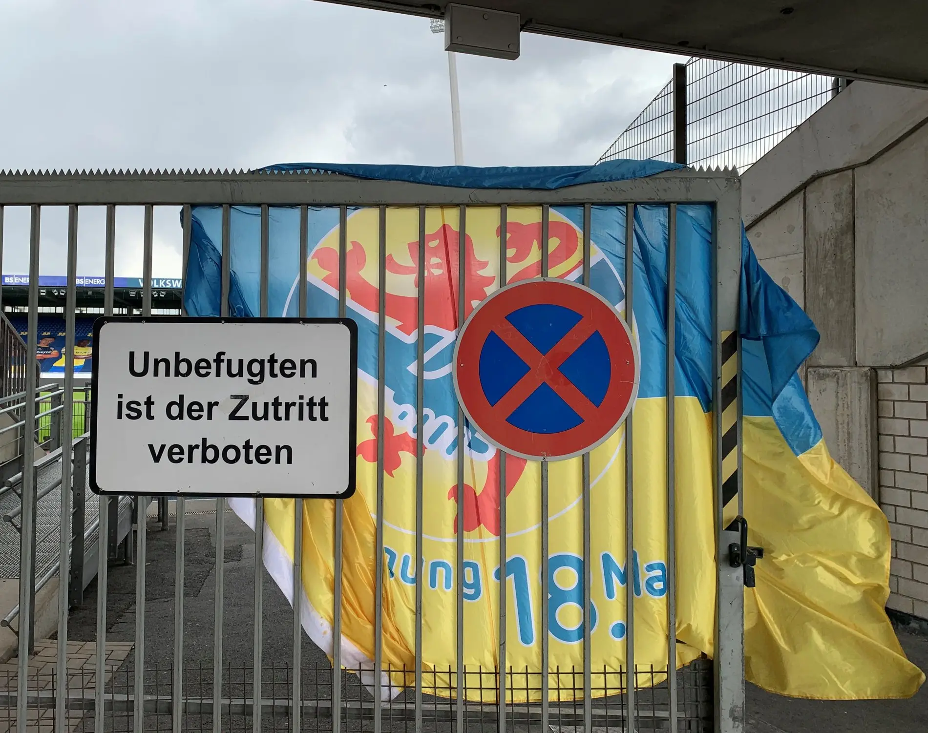 Ein Eisengittertor, dahinter eine Eintracht-Fahne