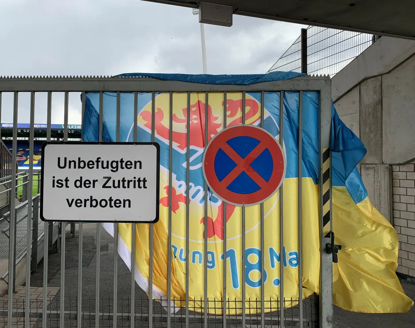 Ein Eisengittertor, dahinter eine Eintracht-Fahne