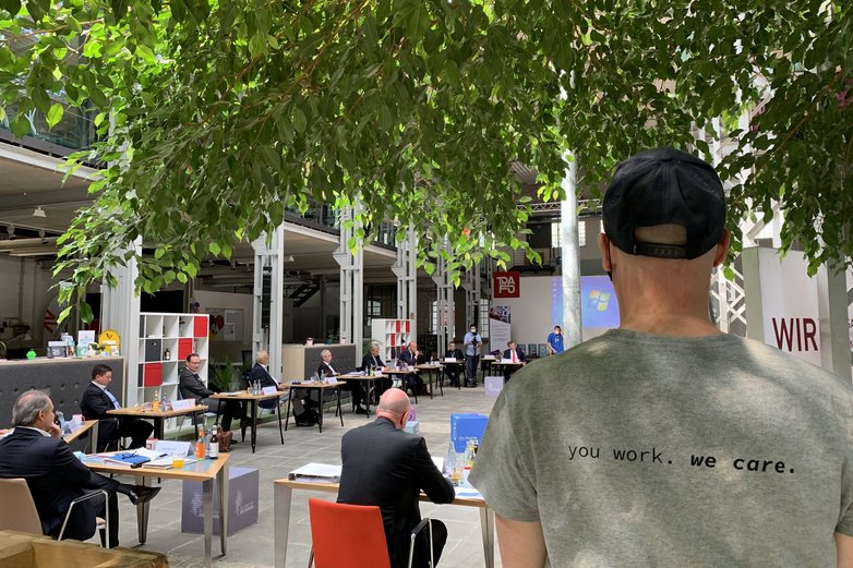 Ein Helfer des Trafo-Hub Braunschweig im Vordergrund, im Hintergrund ein Vortrag.