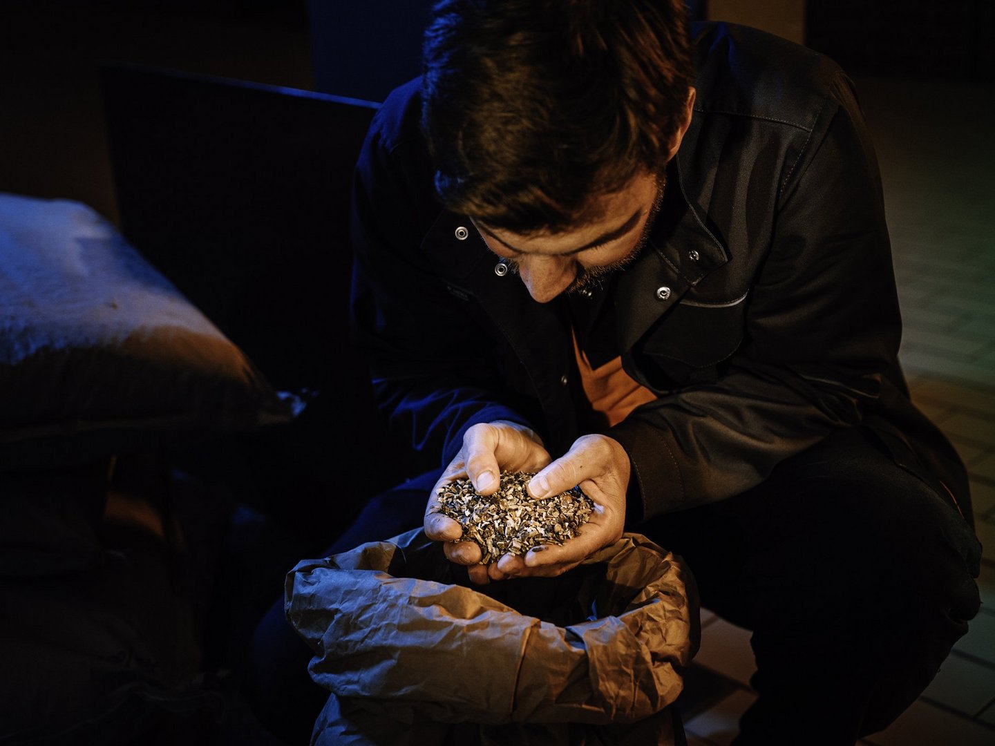 Ein Mann lässt eine Kräutermischung durch seine Hände gleiten.