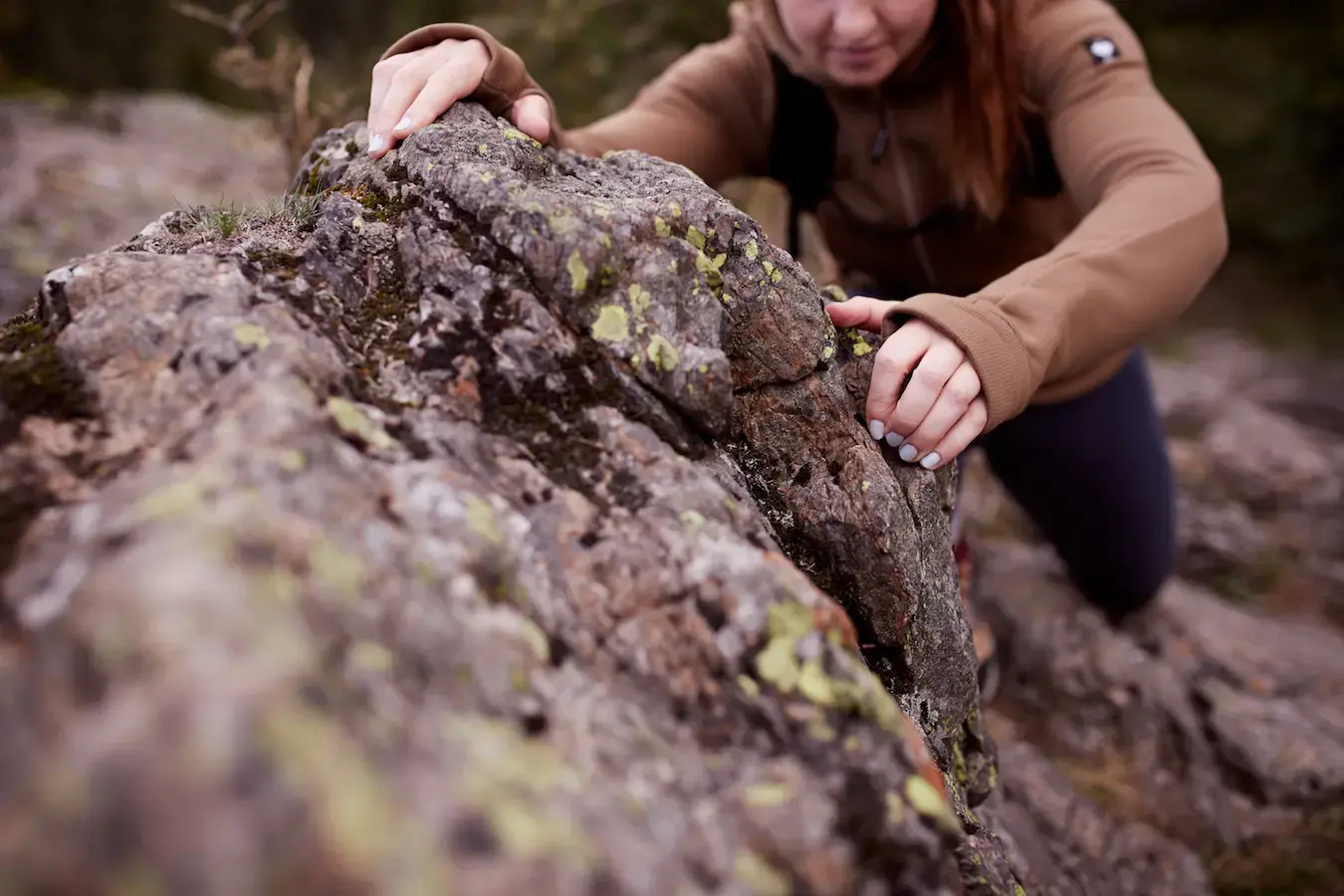 Eine Frau klettert einen Felsen hinauf.