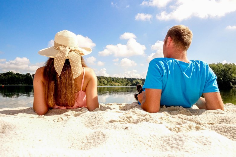 Zwei Badegäste liegen am Strand des Eixer Sees.