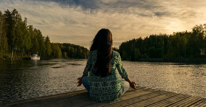 Eine Frau sitzt auf dem Steg vor einem See. (Bildrechte: Shahariar Lenin)