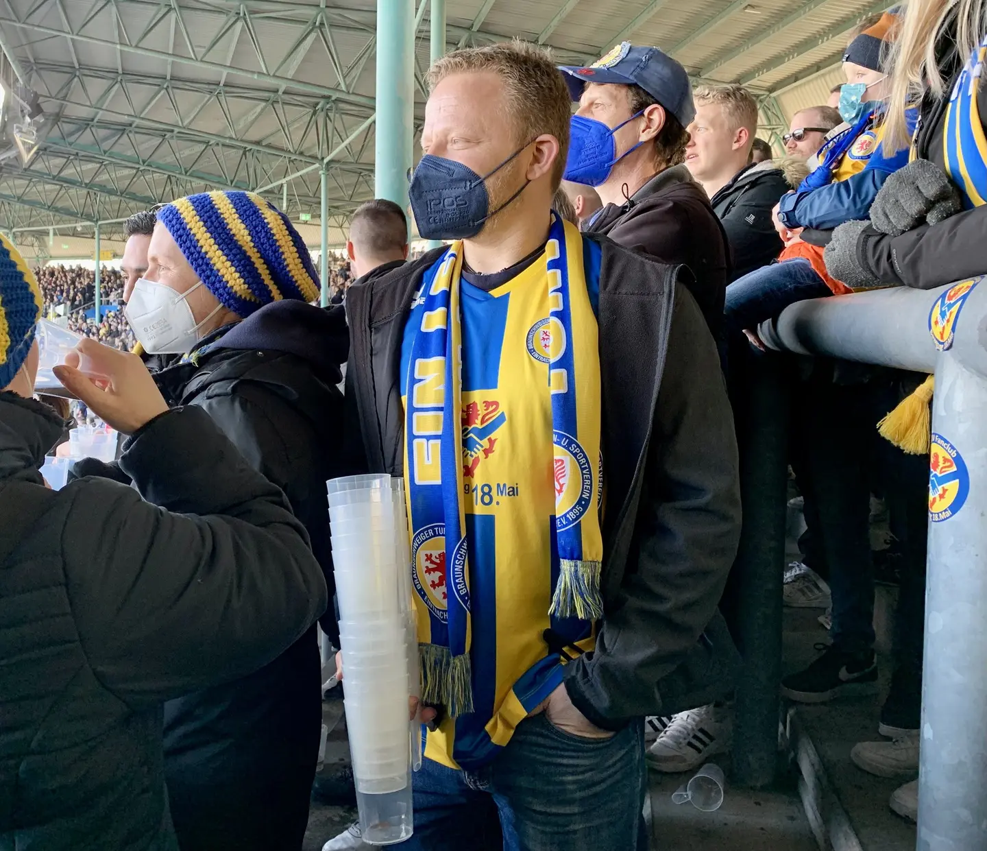 Fans auf der Tribüne in einem Fußballstadion.
