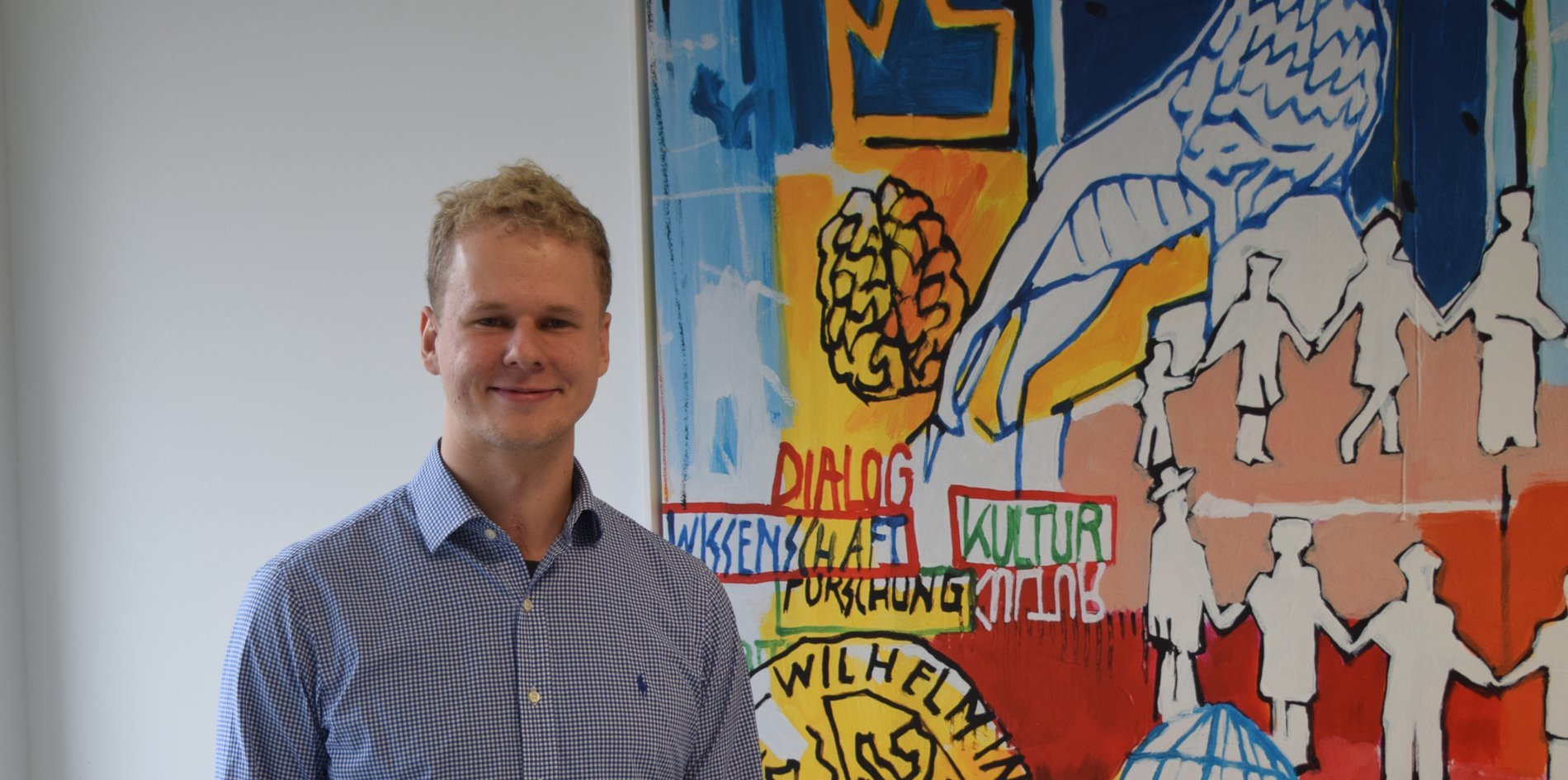 In seinen Geschäftsräumen steht Marcel Engelmann vor einem Bild.