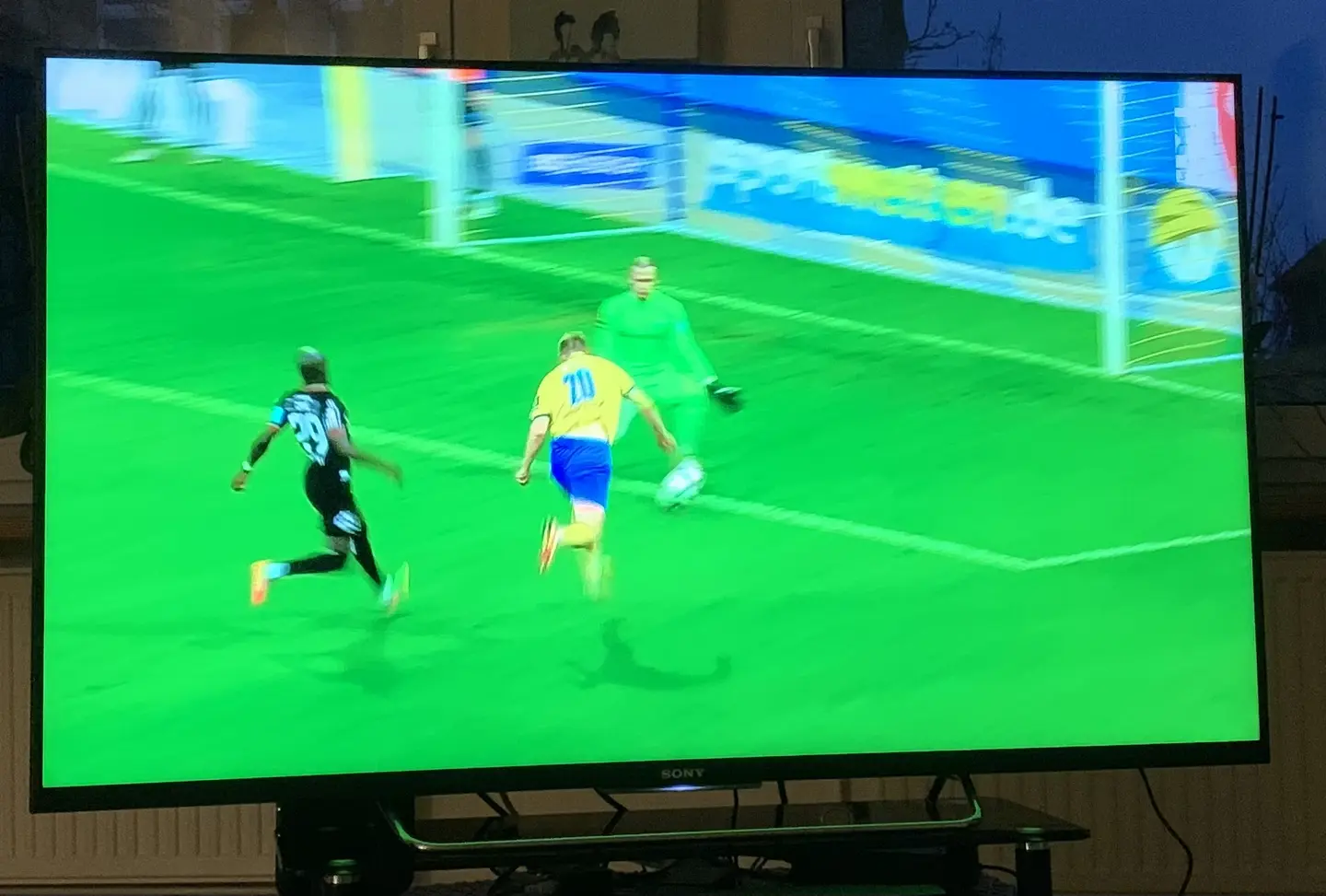 Das Foto zeigt einen laufenden Fernseher, der abgelichtet wurde. Es läuft ein Fußballspiel.