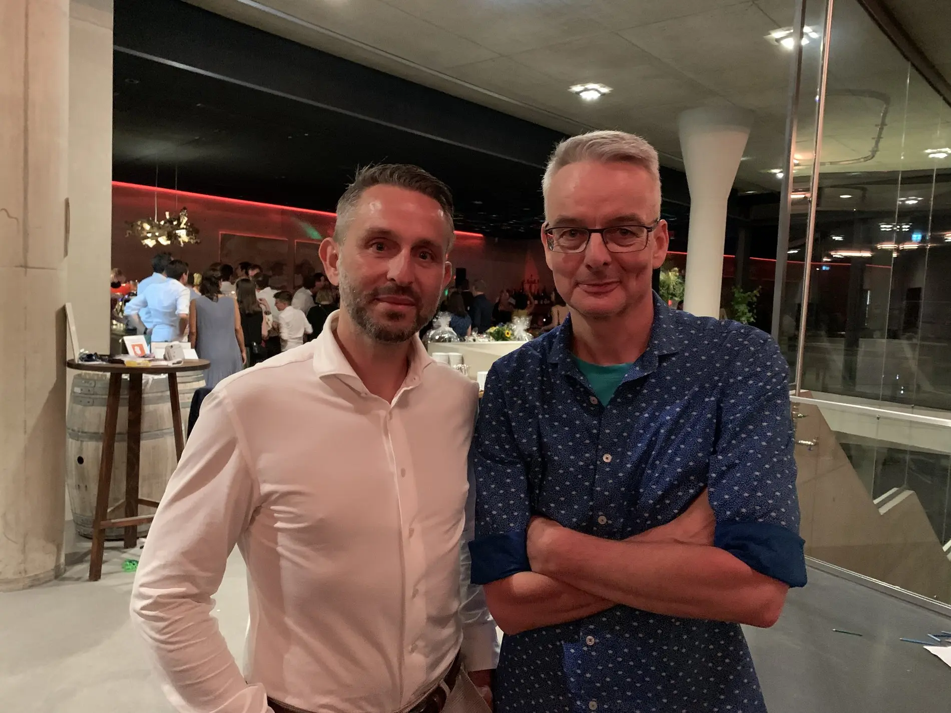 Zwei Männer, einer im blauen und einer im weißen Hemd.