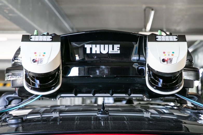 Zwei Laserscanner sind auf der Rückseite des Daches installiert eines schwarzen Testautos.