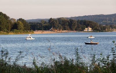 Man blickt vom Ufer auf Segelboote auf dem Salzgittersee. Im Hintergrund ist der sandige Strandabschnitt des Sees zu erkennen.
